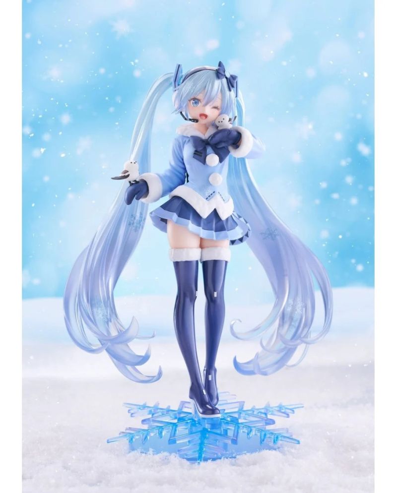 Snow Miku en tenue bleue hivernale sur son socle flocon translucide.